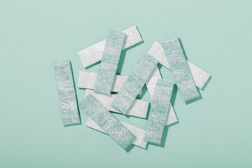Pile of mint gum on mint color background top view