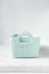pastel green organisation basket with a white background, Plastic green basket for home organisation, pastel green basket with a woven pattern