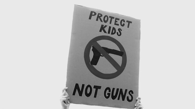Student protest supporting gun control on the road- People march for kids lives at school holding sign banner - Black and white editing