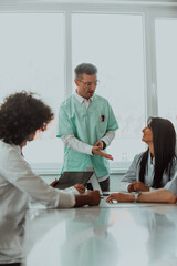 Obraz premium A group of multiethnic medical professionals including doctors, surgeons, and nurses are gathered in a hospital setting discussing patient care and using modern technology to address challenges in