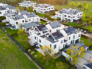 White modern houses with grey roofs in green scenery seen from above