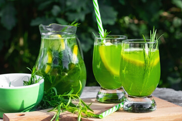 Homemade summer refreshing tarragon lemon drink on patio table