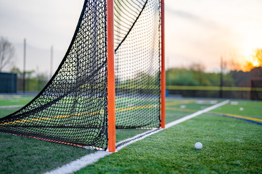 Late afternoon photo of a lacrosse goal on a synthetic turf field before a night game.
