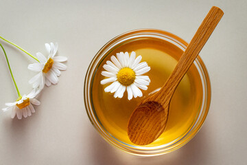 Chamomile syrup in a small bowl and jar on the kitchen table