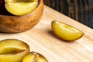 Ripe dark - colored plums sliced on the table
