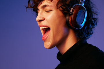 Male singer wearing headphones listening to music and singing with his mouth open, sound recording,...