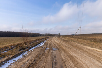 Fototapeta na wymiar a broken country road at the beginning of spring