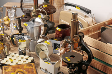 Many different items on wooden table. Garage sale