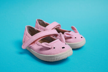 Pair of cute baby shoes on light blue background