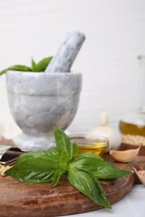 Different ingredients for cooking tasty pesto sauce on white table