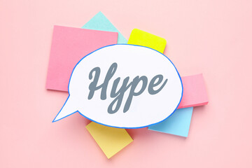 Paper speech bubble with word Hype and notes on pink background, flat lay