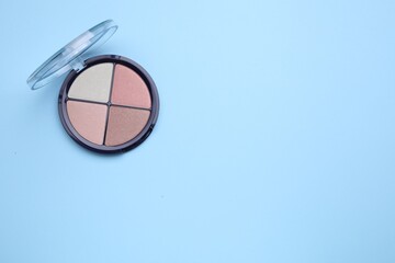 Contouring palette on light blue background, top view with space for text. Professional cosmetic product