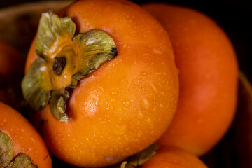 Ripe orange persimmon covered with drops