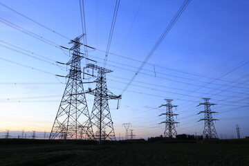 In the evening, the silhouette of high voltage towers