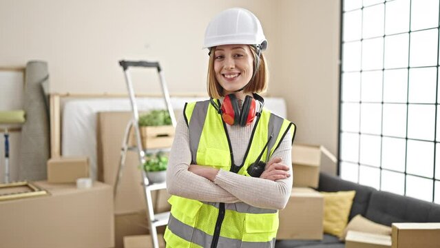 Young blonde woman architect smiling confident standing with arms crossed gesture at new home