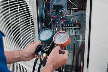 Technician is checking air conditioner,measuring equipment for filling air conditioners.