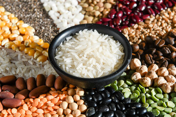 Bowl with raw white rices on various seeds grain