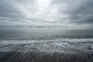 Black Sea on the Sochi coast and a pebble beach on a sunny day with clouds, Sochi, Krasnodar Territory, Russia