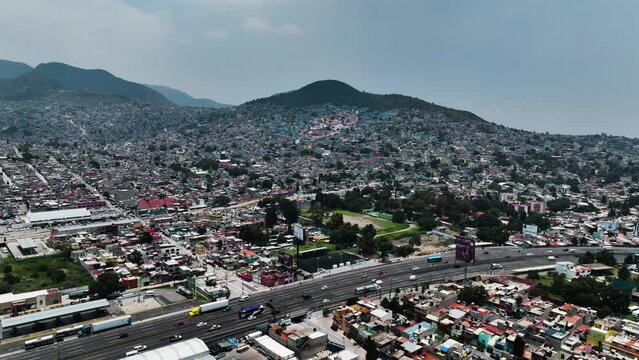 Aerial view over a road approaching a face in the hills of Ecatepec de Morelos, Mexico