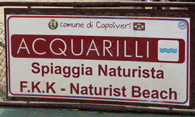 Signpost at beginnig of pathway to Acquarilli Beach, a dark sand beach for nudist situated in the gulf of stella, Elba island, Italy