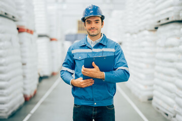 Smart engineer man worker wearing safety helmet doing stocktaking of product management in...