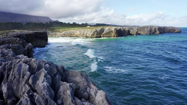 Beautiful coast where the waves break with cliffs and high mountains in the north of Spain, Asturias.