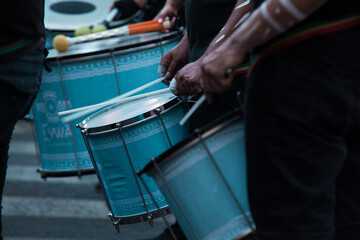 Close up band playing drums in the street at a public event.