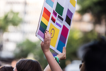 Hands holding poster with many different colours, supporting the equality of all humans.