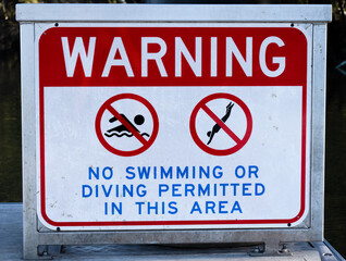 Warning sign prohibiting swimming and diving.