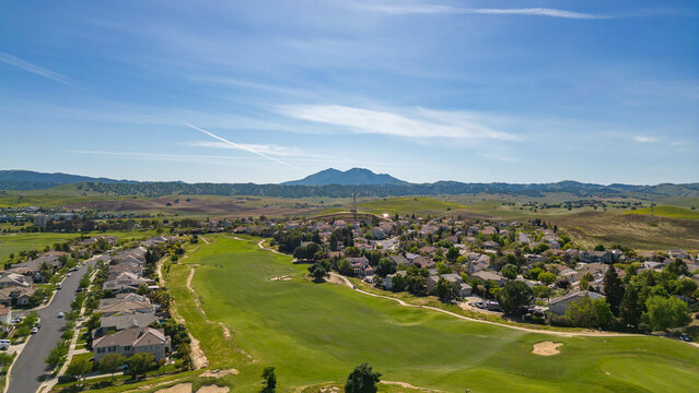 Drone photos over a golf course community in California with a blue sky and houses