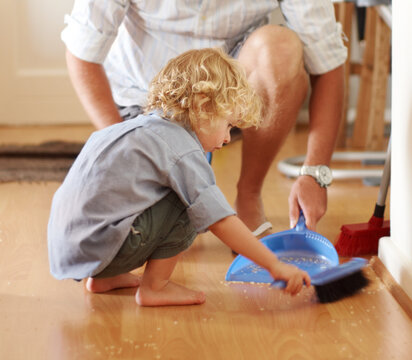 Father with boy child sweeping up mess, family cleaning together and help with broom and dustpan. Hygiene, chores and house work, man and kid bonding, working together and helping with dirt on floor