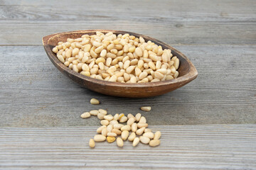 Pine nuts in a small wooden bowl