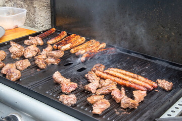 Saucisses grillant sur une plancha