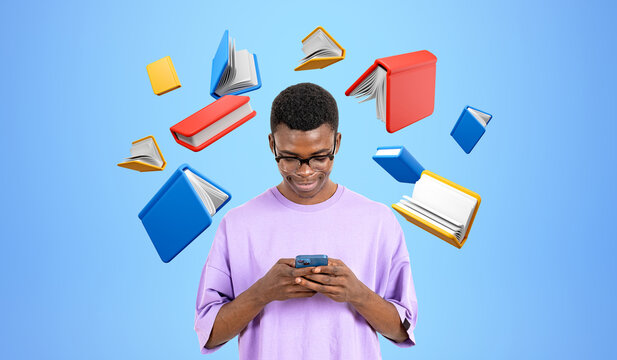 Black man typing in smartphone flying books and education concep