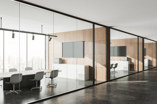Modern office room interior with table and chairs behind glass doors, window