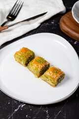 Baklava with pistachio on a dark background. Traditional Turkish baklava. Local name ankara sarmasi