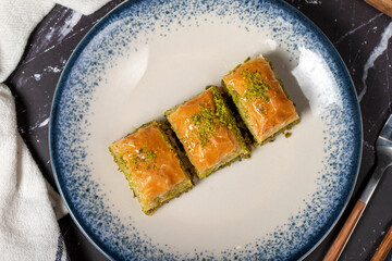 Baklava with pistachio on a dark background. Traditional Turkish baklava. Top view