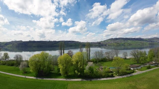 FPV flying over a rural spring landscape with lake in Switzerland