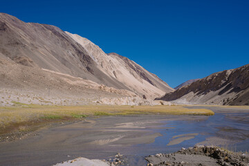 grassland, small river and mountain, blue sky at Ladakh, India