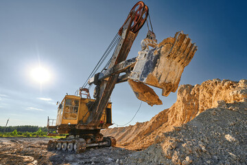 Shovel mining excavator operates in large open chalk quarry