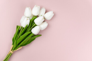 bouquet of white tulips on a pastel pink background with a copy space for your text, spring flatlay composition for invitation, promotion, banners, card