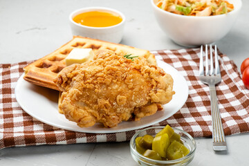 Traditional American cuisine, waffles and a piece of deep-fried chicken.