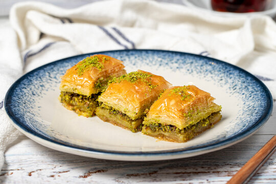 Pistachio baklava on wood background. Traditional Turkish baklava with pistachio. Sherbet dessert. Close up