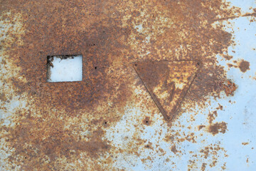Rusty metal surface, scratched and peeling blue paint. The sign "dangerous" on the surface of the sheet.