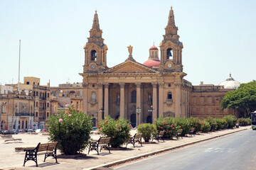 Saint Publius Parish Church with town square at City of 	Floriana on a sunny summer day. Photo taken August 9th, 2017, Valletta, Malta.