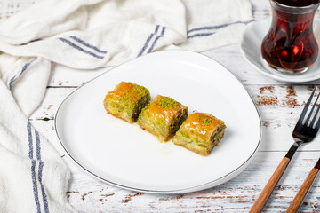 Baklava with pistachio on a wood background. Traditional Turkish baklava. Local name ankara sarmasi