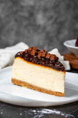 Chocolate cheesecake on dark background. Delicious cheesecake with chocolate chips and cream. Close up