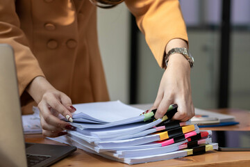 Fototapeta na wymiar Businesswoman hands working on stacks of paper documents to search and review documents piled on table before sending them to board of directors to use correct documents in meeting with Businessman