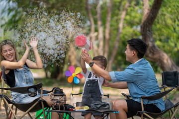 Happy family on a relaxing vacation By camping in the park