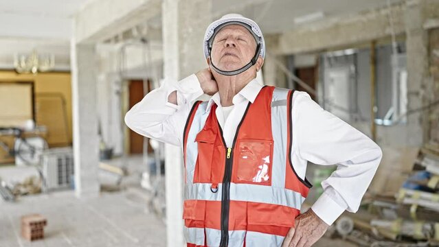 Senior grey-haired man architect stressed at construction site
